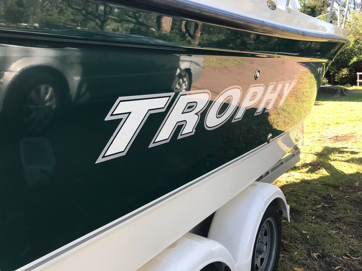 Mirror-gloss dark green hull of a Trophy trailer boat after polishing