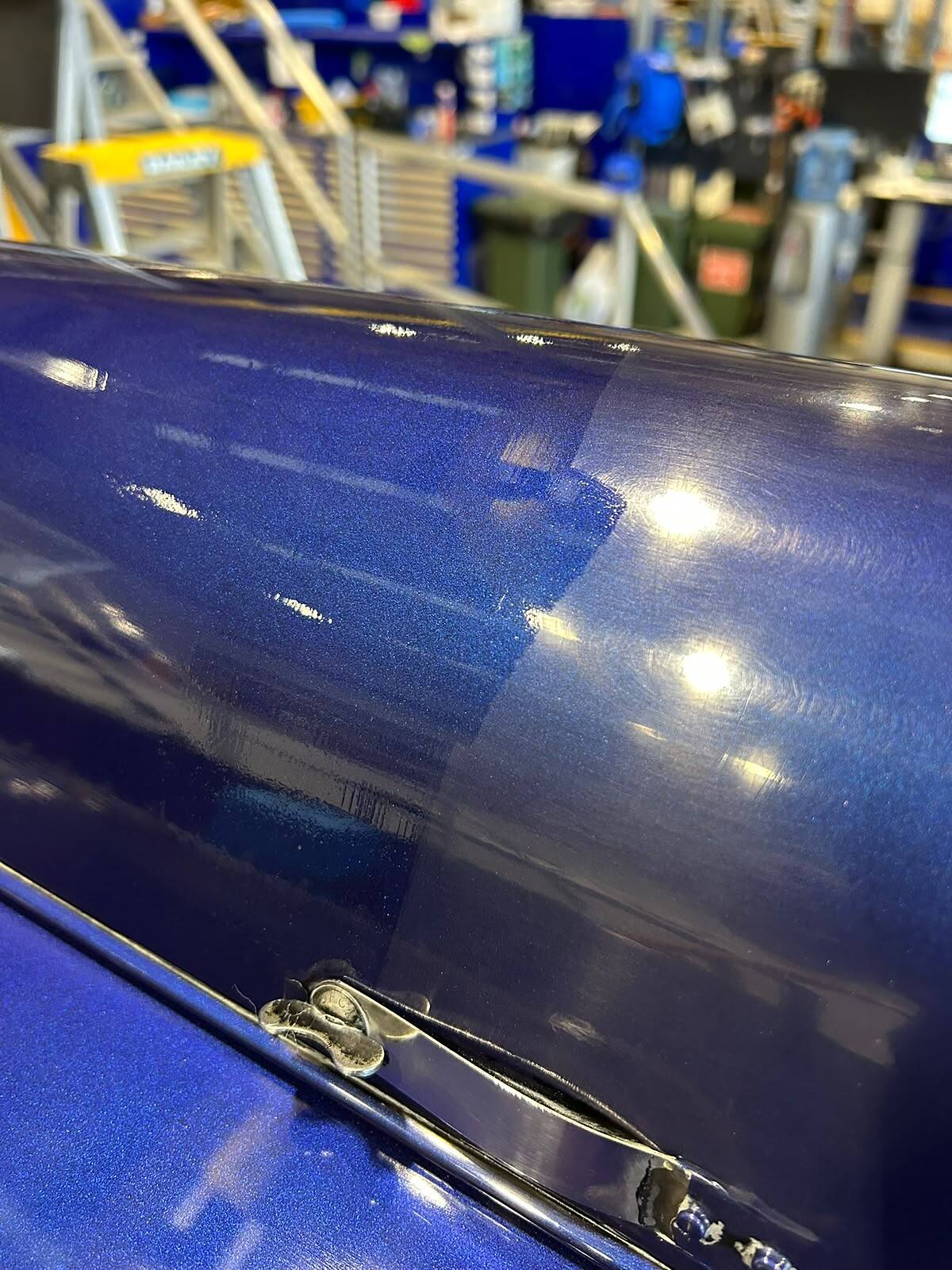 Deep blue metallic boat hull machine polished to a mirror gloss