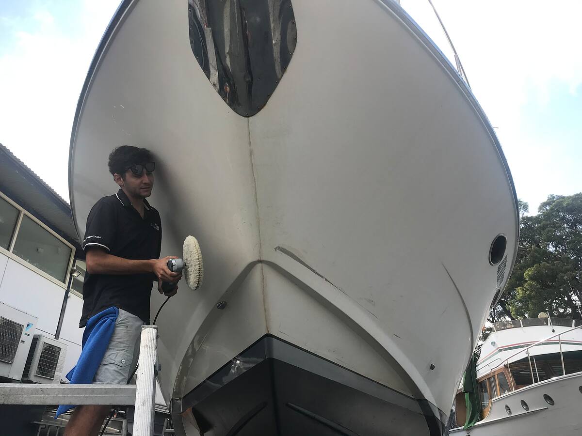 Machine polishing the bow of a motor cruiser on the hardstand