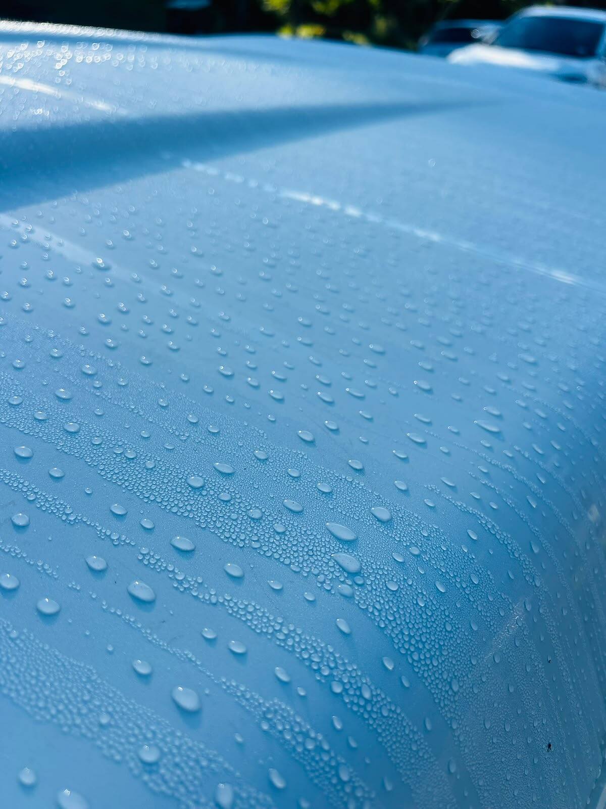 Water beading on blue paint protected with a ceramic coating